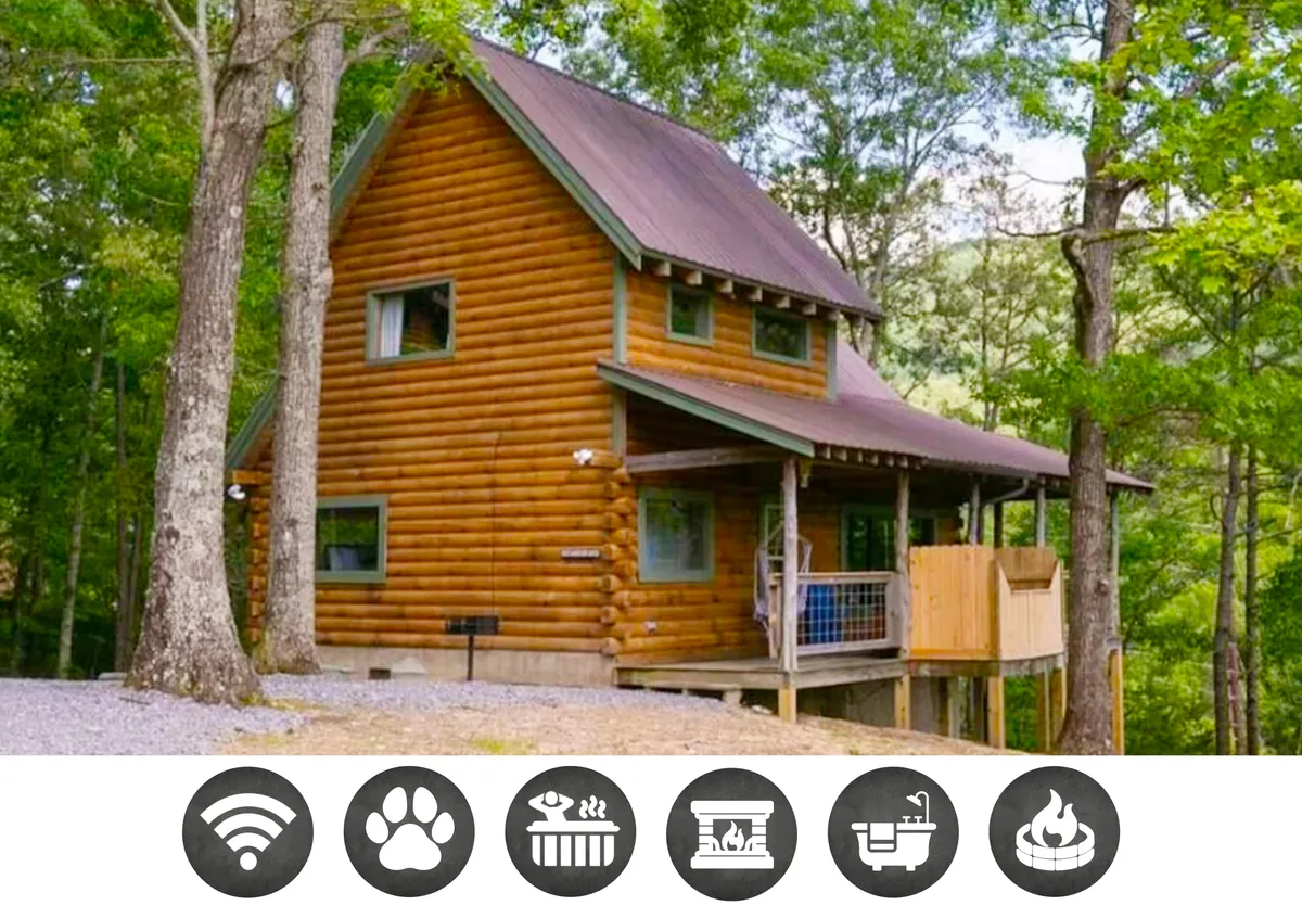 The image features a charming log cabin nestled among tall trees, with a spacious deck that invites guests to relax and soak in the tranquil mountain surroundings. The cozy exterior, warm wood tones, and serene natural setting evoke a sense of peace and escape, while the deck hints at outdoor gatherings, sunset views, and close connection with nature.